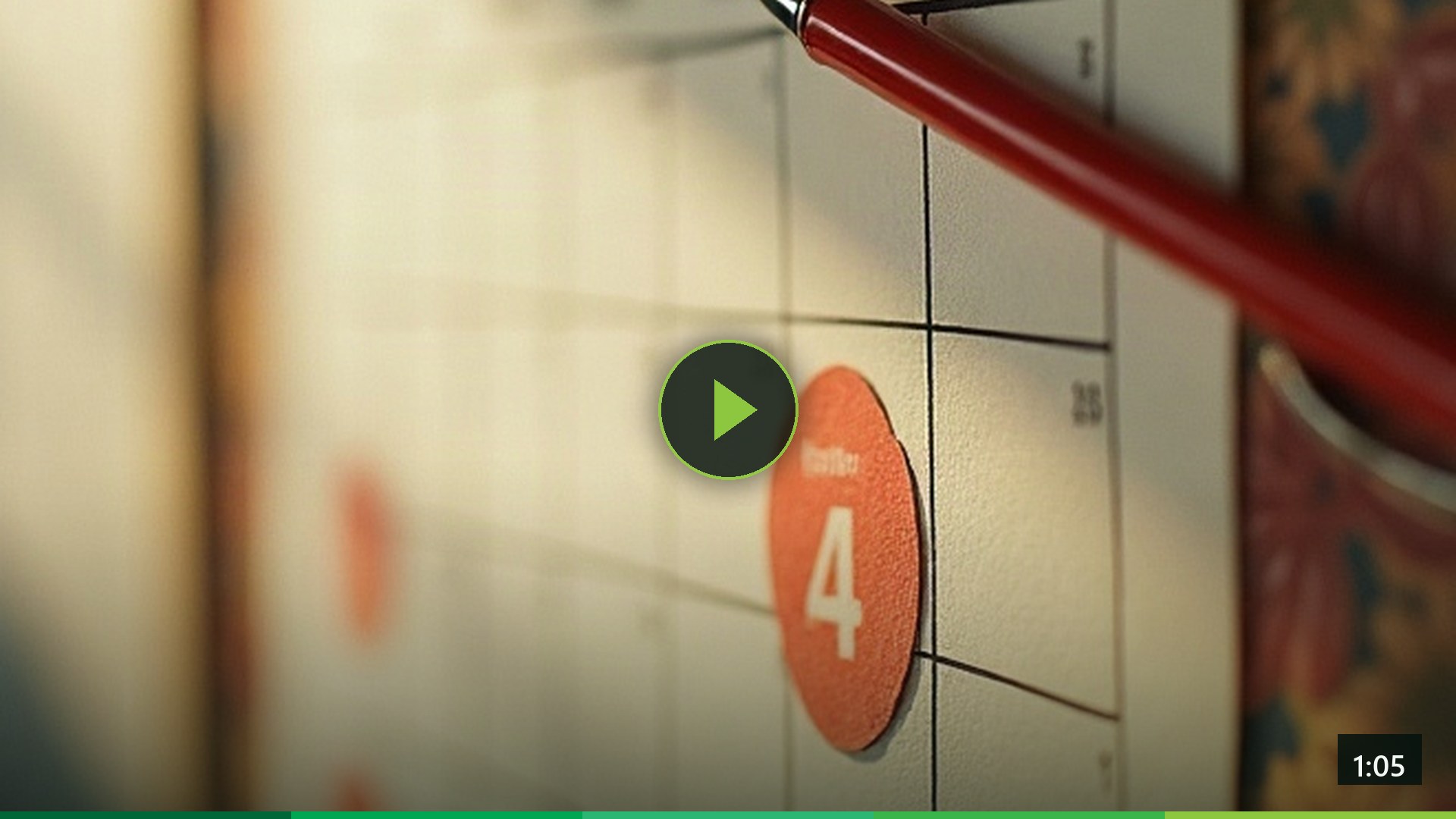 A red pen resting on a wall calendar with one date marked.